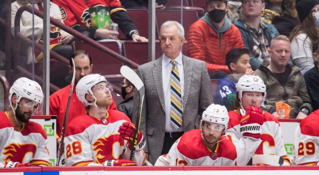 Calgary Flames Head Coach Darryl Sutter is seen standing behind a bench full of Flames players