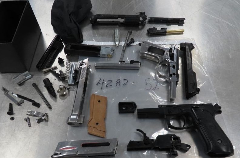 Several guns are laid out on a table alongside ammunition