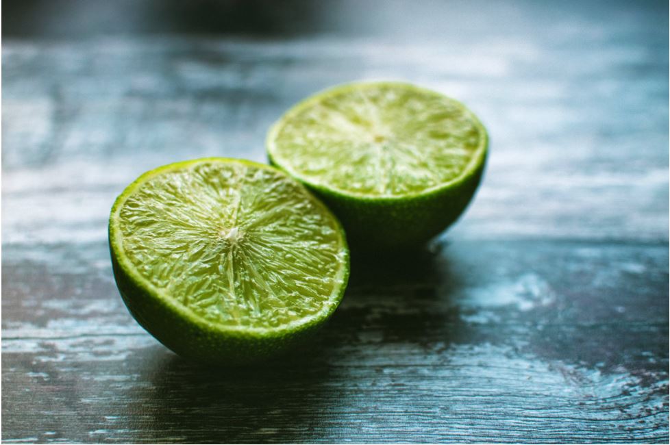 A lime sliced in half is shown on a table.