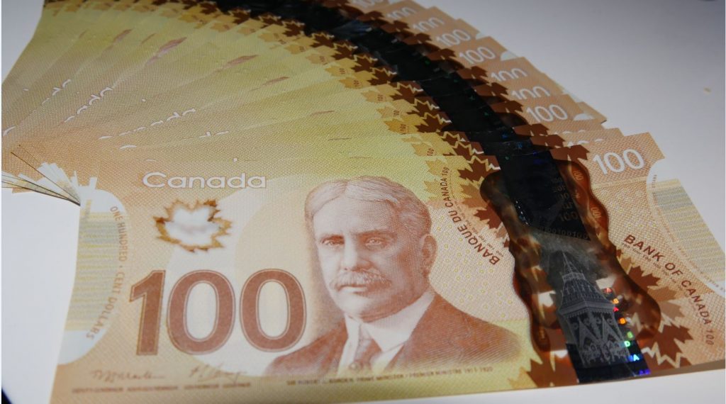 Canadian currency shown in one hundred dollar bills.