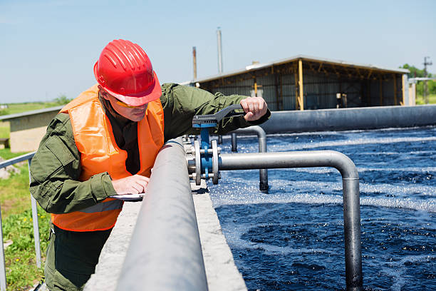 An engineer controlling the quality of water , aerated activated sludge tank at a waste water treatment plant.