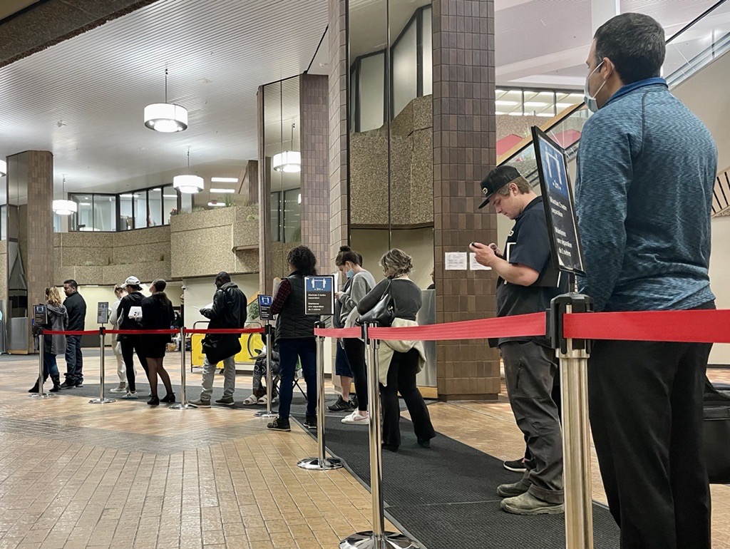 People wait in line at a Service Canada location inside the Harry Hays building in Calgary for passport renewals