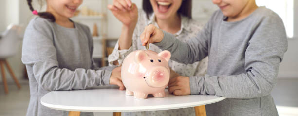 Happy mother and little children saving up money for future plans and dream projects. Family finance, budget management, financial literacy for kids concepts. Website design header, piggy bank closeup