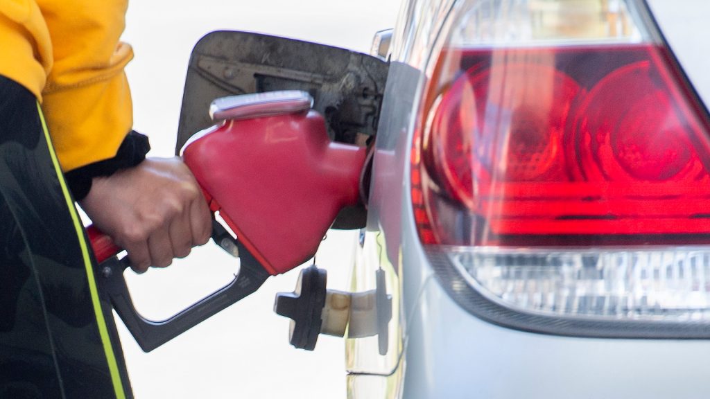 A motorist is shown filling up their car at a gas station.