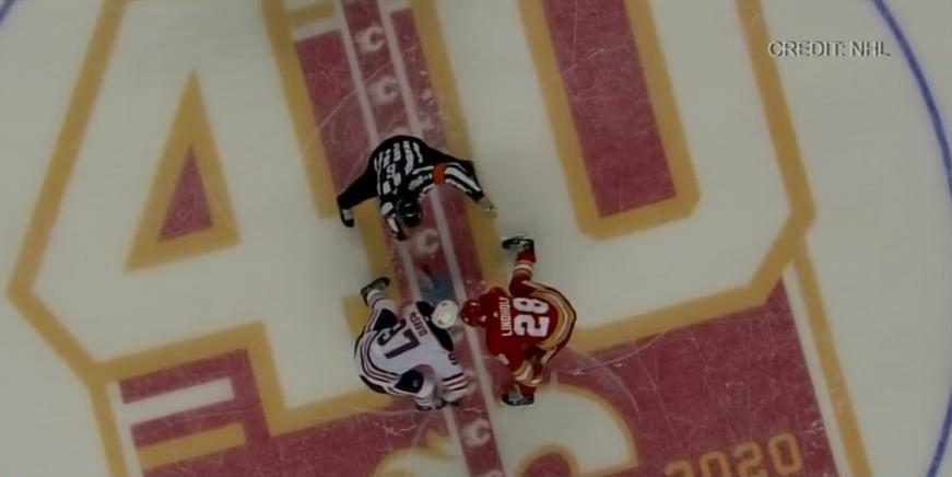 Edmonton Oilers and Calgary Flames faceoff at centre ice.