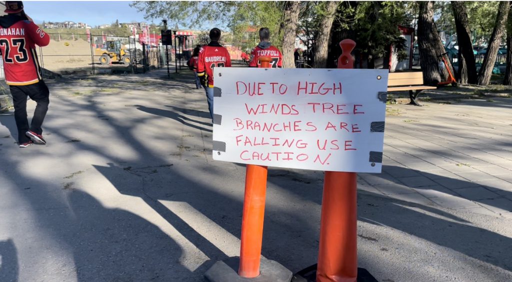 Sign that reads "Due to high winds tree branches are falling use caution"