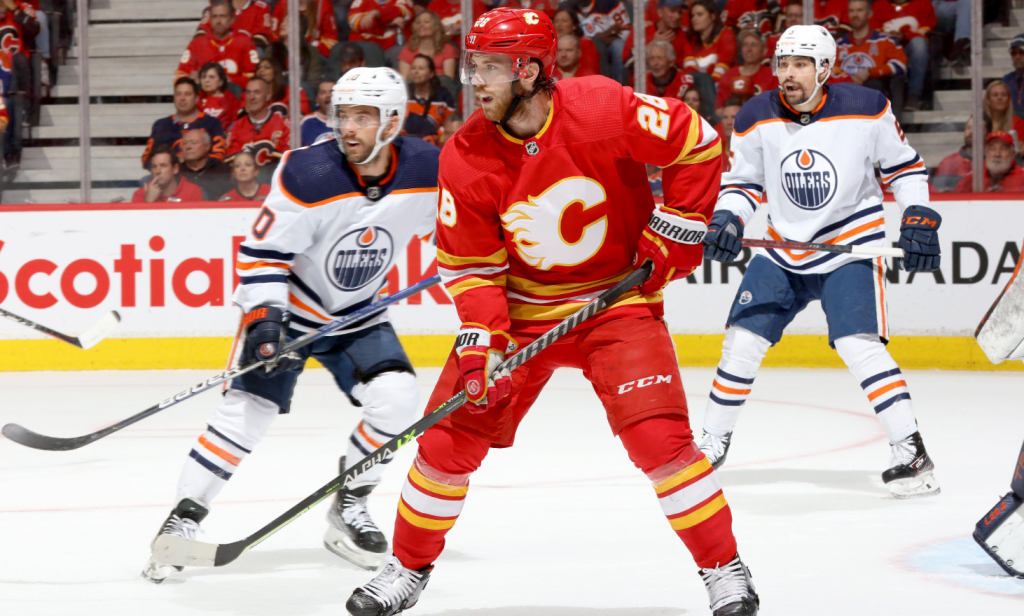 Calgary Flames and Edmonton Oilers players during a play on the ice