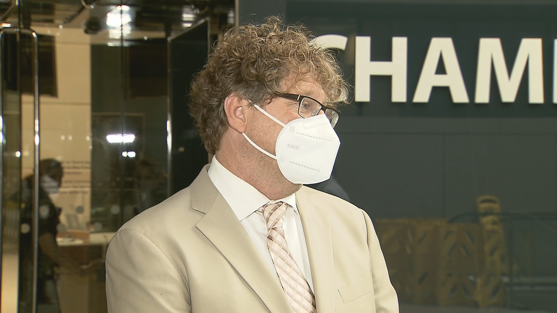 Calgary Ward 9 councillor Gian-Carlo Carra speaks to reporters wearing a face mask and a light coloured suit and tie
