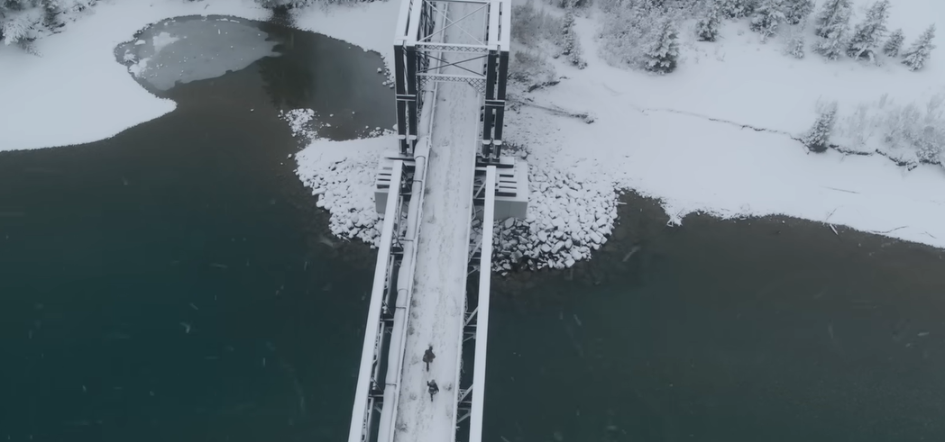 Two people cross a snowy bridge in the first footage of HBO's The Last of Us series