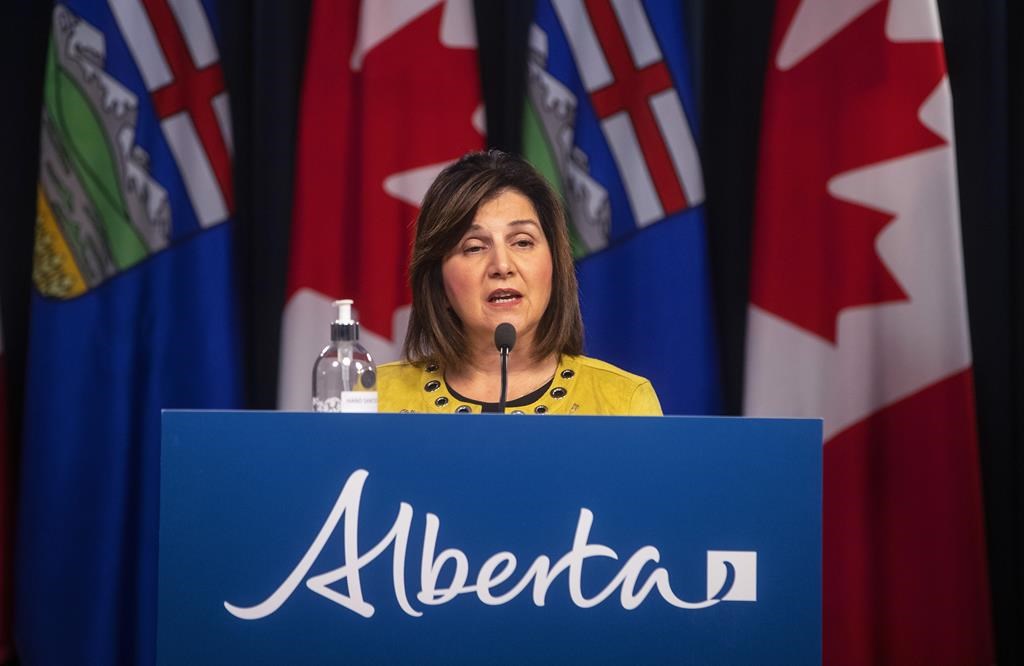 Alberta Education Minister Adriana LaGrange stands at a podium with 'Alberta' written on the front