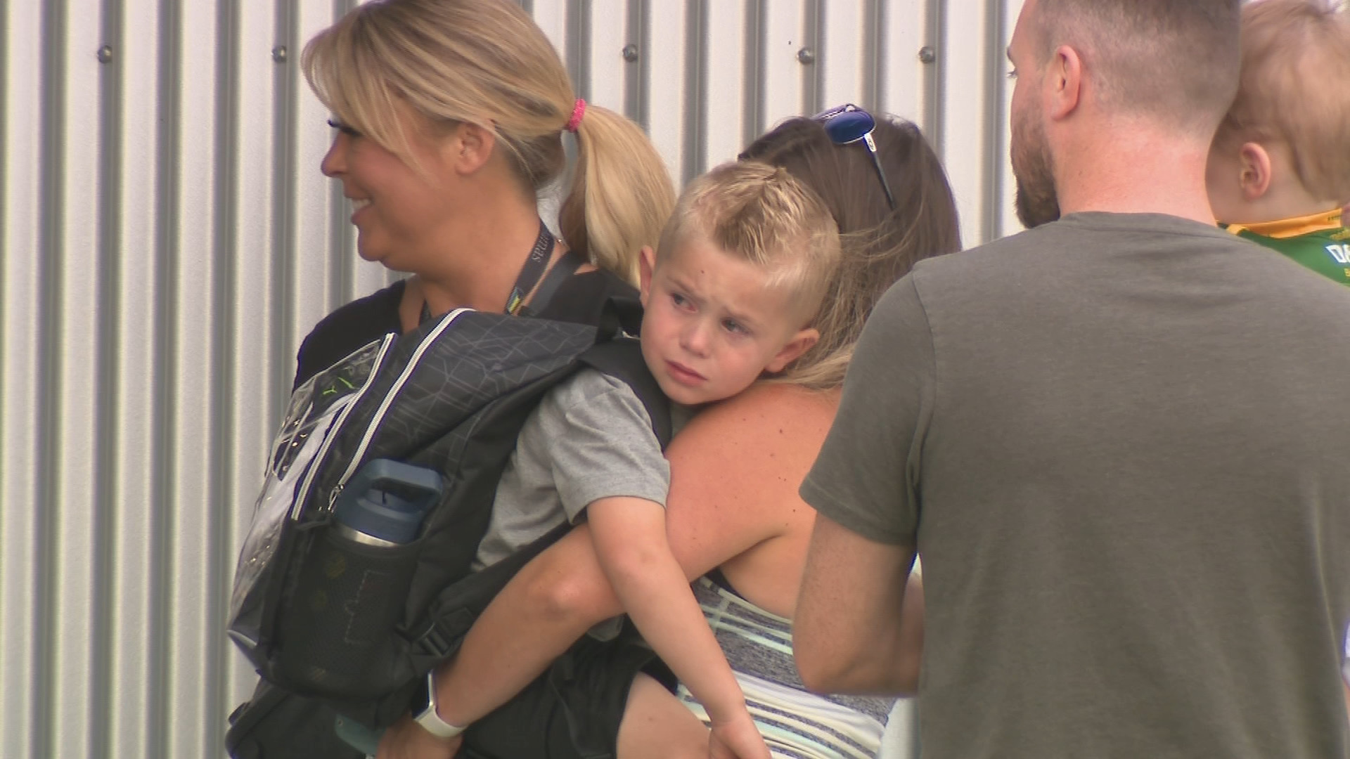 A boy in tears is held by a woman outside Mahogany Elementary School