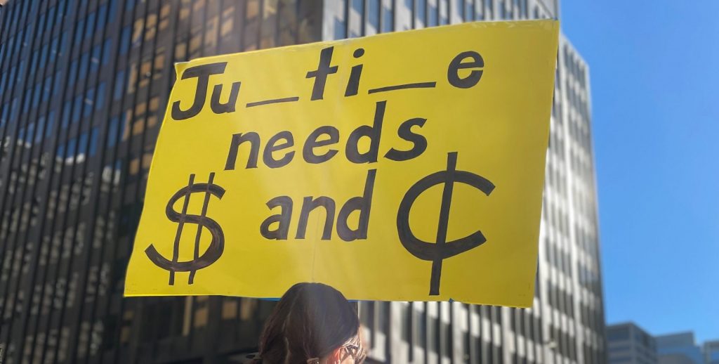 A protester holds a sign at a demonstration by Alberta's criminal defence lawyers