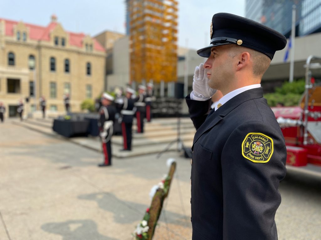 A firefighter stands at a memorial honouring firefighter lives lost in the line of duty in Calgary