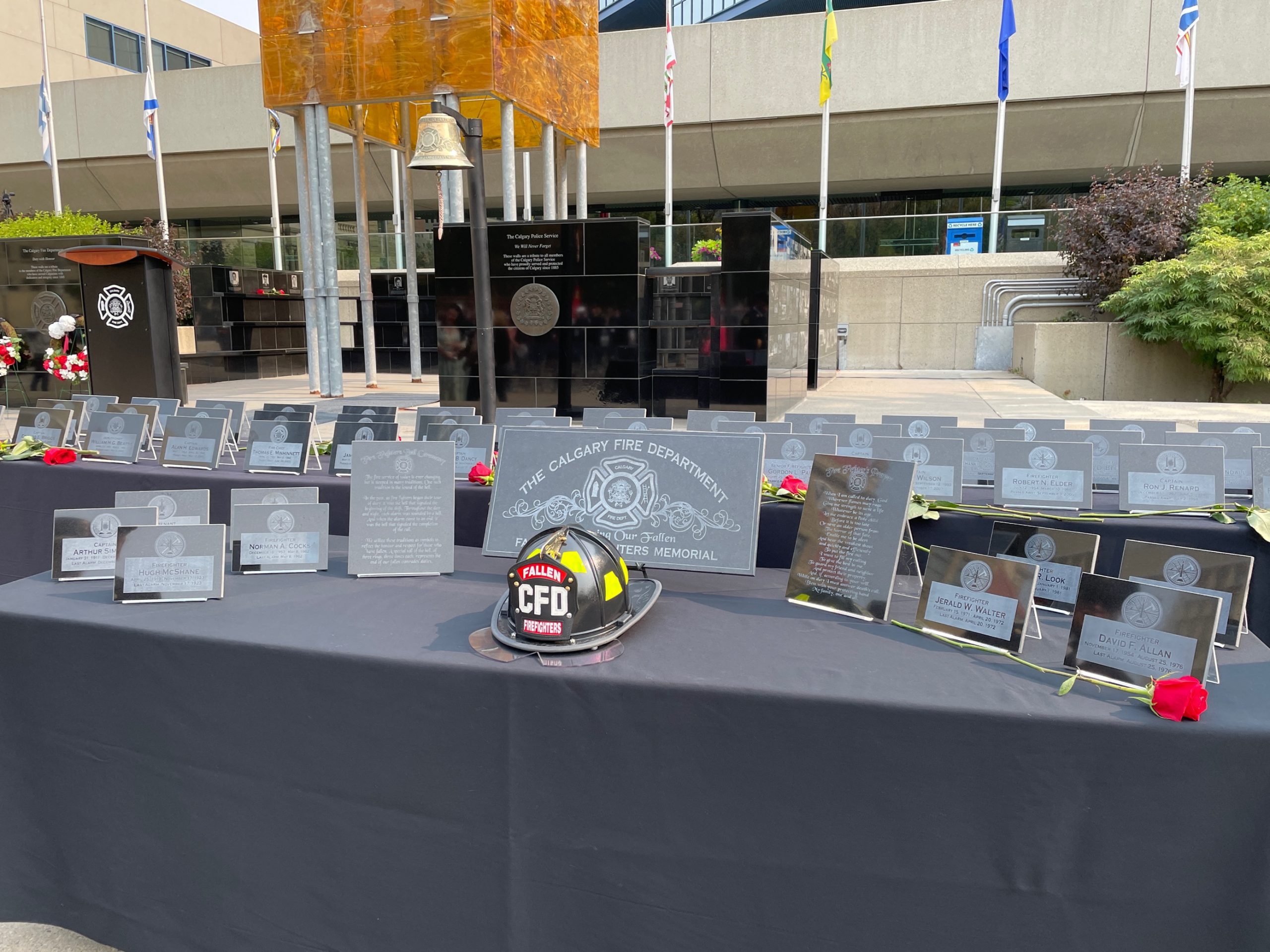 Plaques with the names of firefighters that lost their lives while in the line of duty rest on a table in Calgary