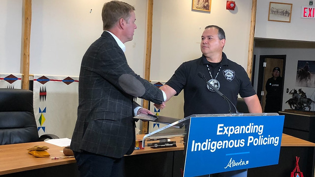 Tyler Shandro, Minister of Justice and Solicitor General (left), shakes hands with Chief Ouray Crowfoot, Siksika Nation.