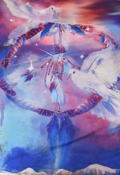 A comforter with an image of a dream catcher and two white birds on it.