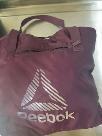 A purple Reebok duffle bag