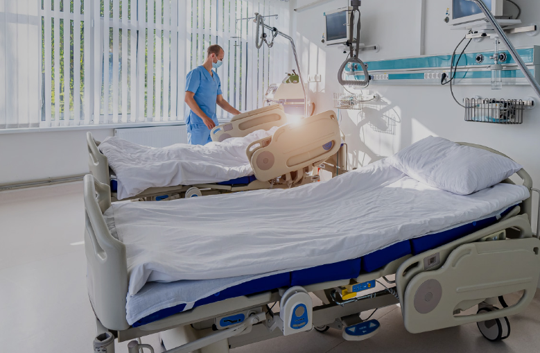 hospital worker in blue smock at hospital beds