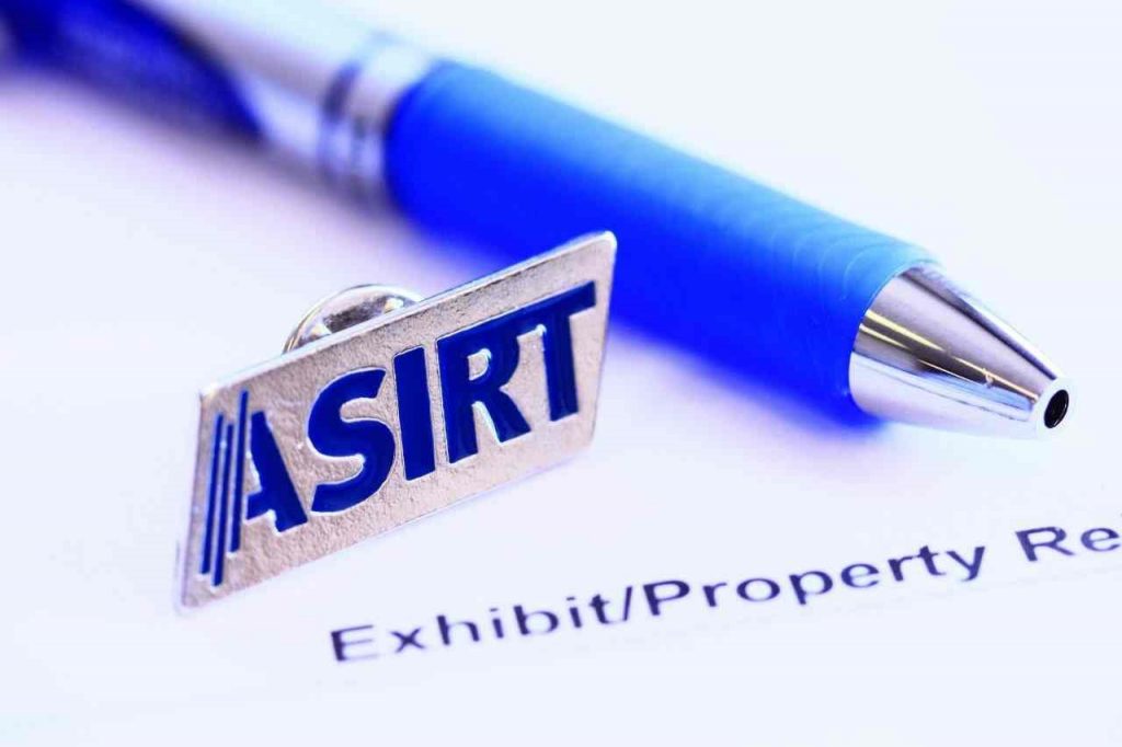 An Alberta Serious Incident Response Team (ASIRT) pin, pen, and paper.