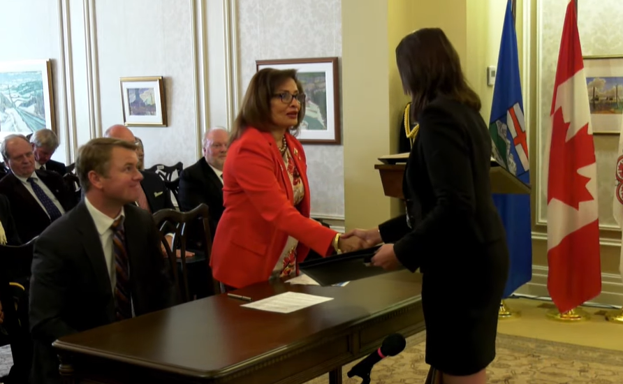 Danielle Smith shakes hands with Alberta Lieutenant Governor Salma Lakhani as she is sworn in as premier