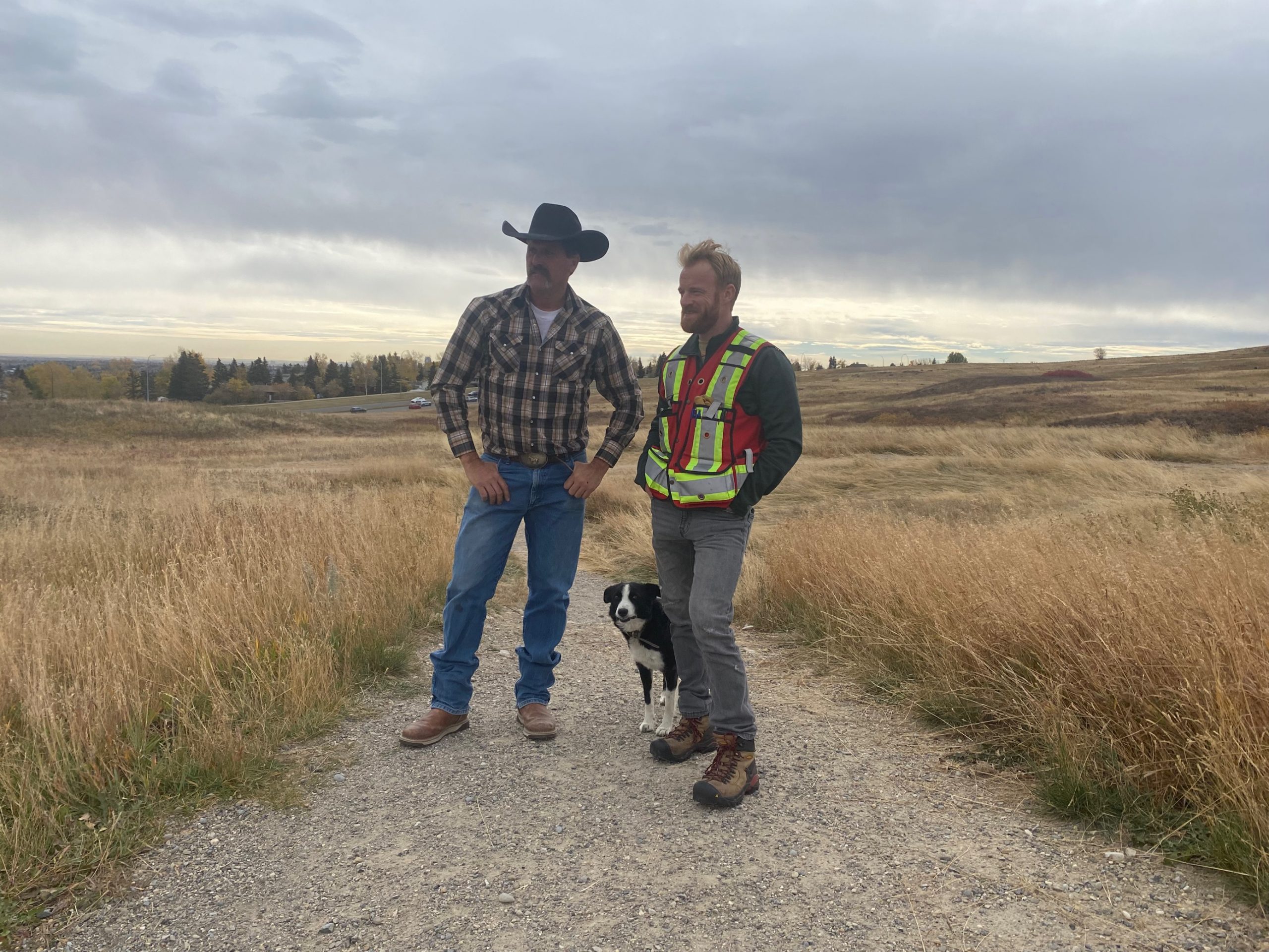 Robert Fink, left, looks at the field in Nose Hill Park with Andrew Phelps, who works with The City of Calgary