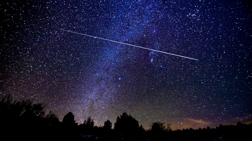 a picture of a meteor shower with Milky Way Galaxy and stars