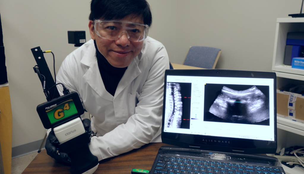 A picture showing an engineering professor holding a portable ultrasound device