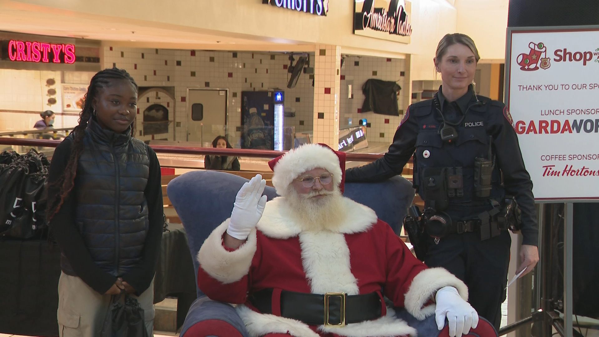 A student, left, poses with Santa Claus and a Calgary police officer