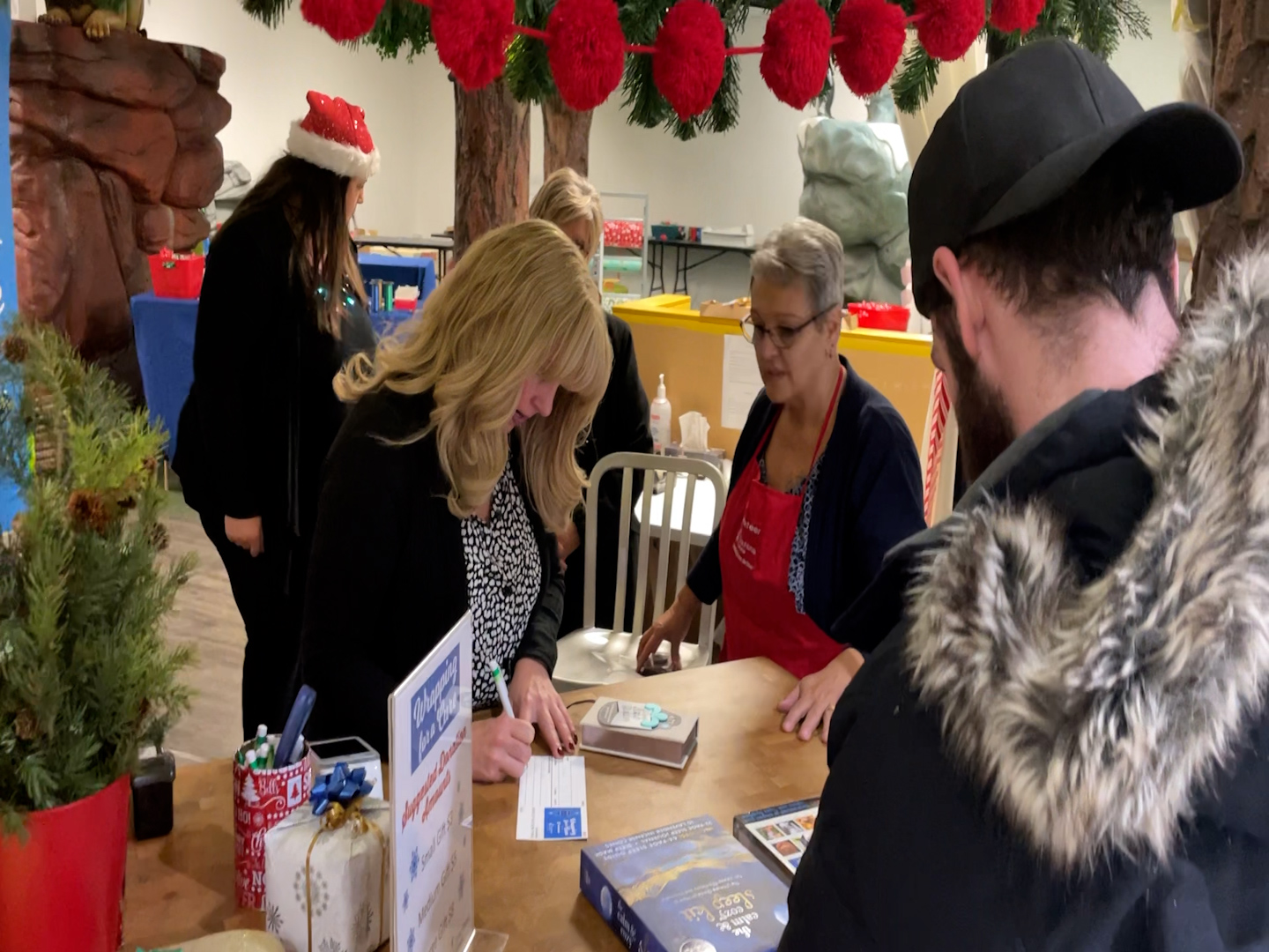 Volunteers wrap gifts at the Cystic Fibrosis wrapping station inside Southcentre Mall in Calgary