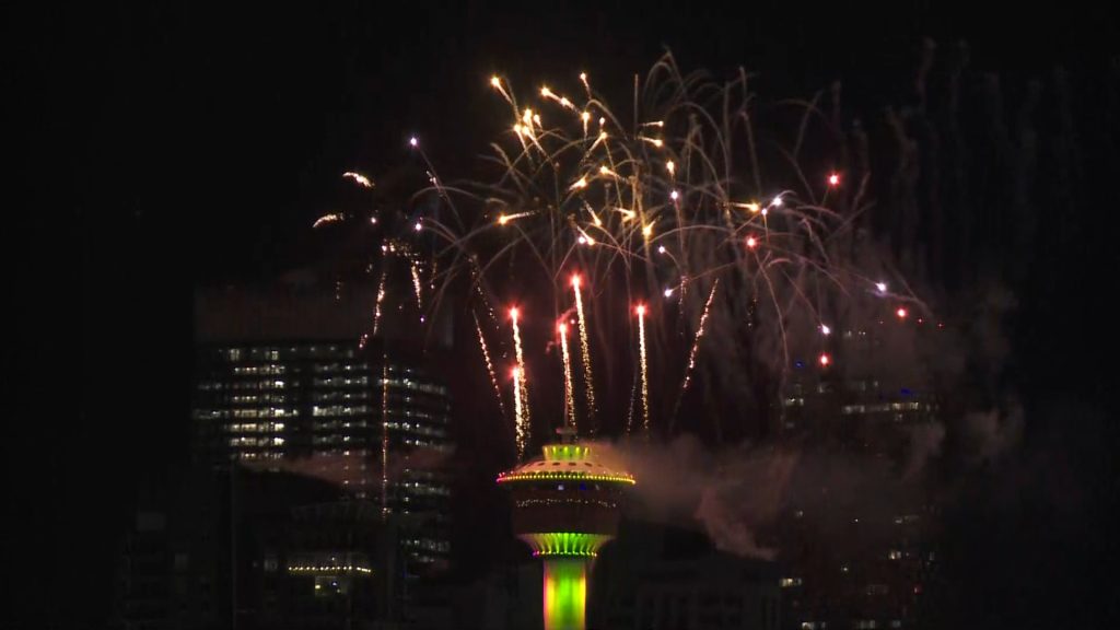Fireworks go off from atop the Calgary Tower at night