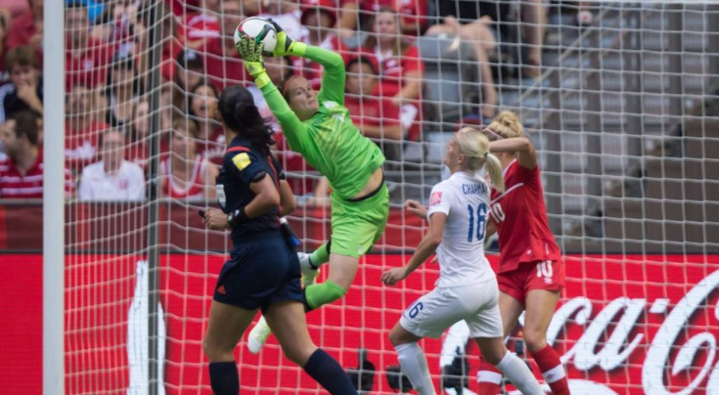 Canada goalkeeper Erin McLeod makes a save in front of England's Katie Chapman