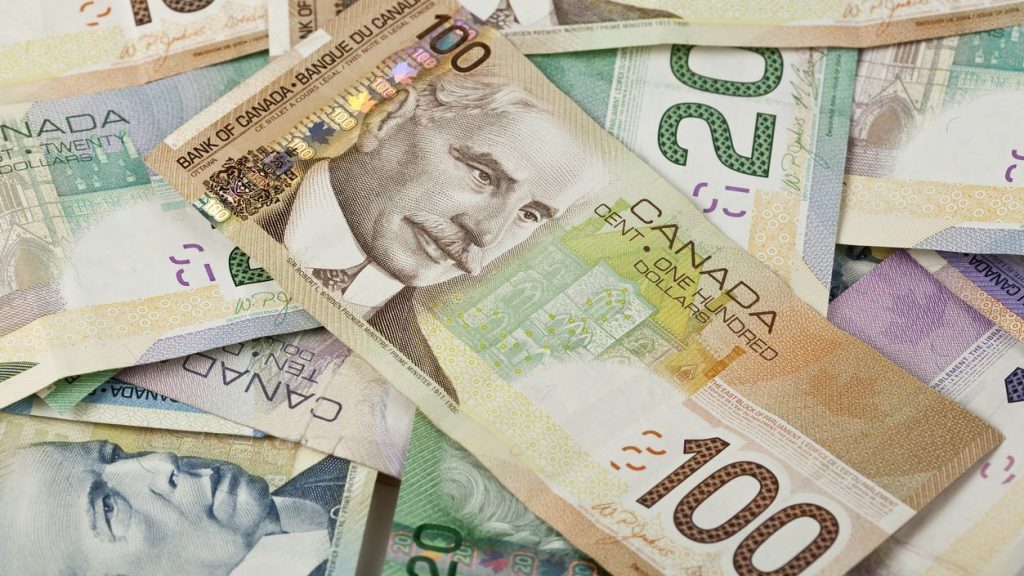 Canadian $100, $20 and $10 bills lie in a pile