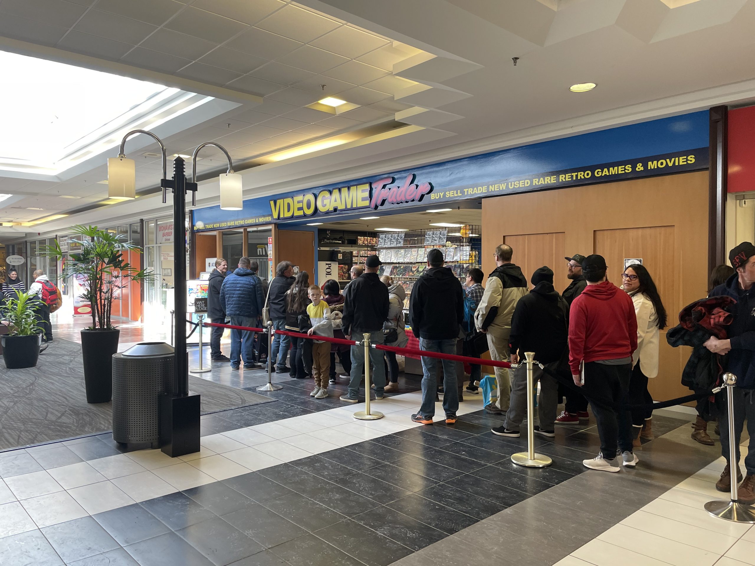 A line of people outside Video Game Trader in Lake Bonavista Promenade in Calgary