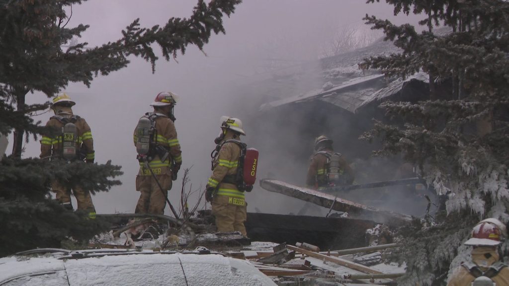 A group of firefighters work on the scene of a home that was destroyed in an explosion in northeast Calgary