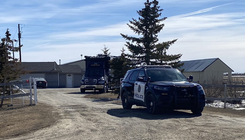 A Calgary police vehicle and a Mobile Command Vehicle at an acreage east of Chestermere, Alta