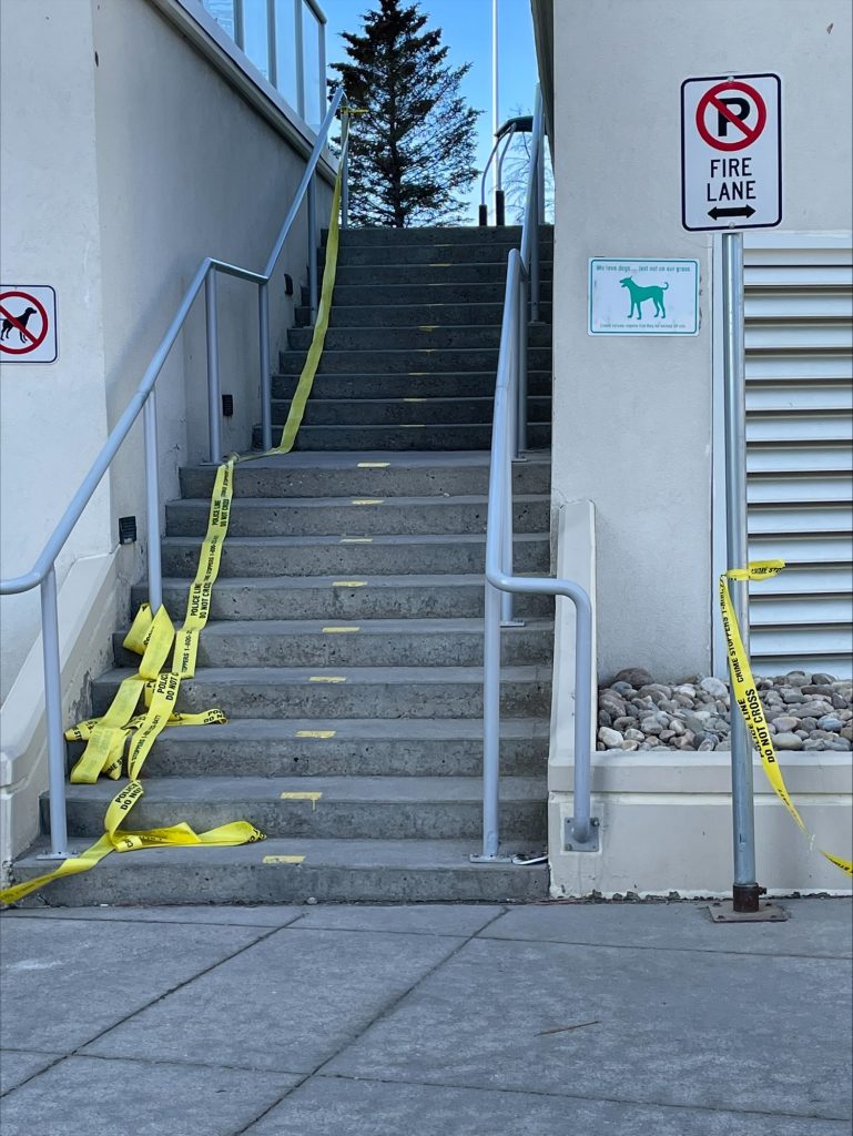 police tape is seen near a stairwell. Police were called to an area in southwest calgary for reports of a medical collapse but later found two people dead