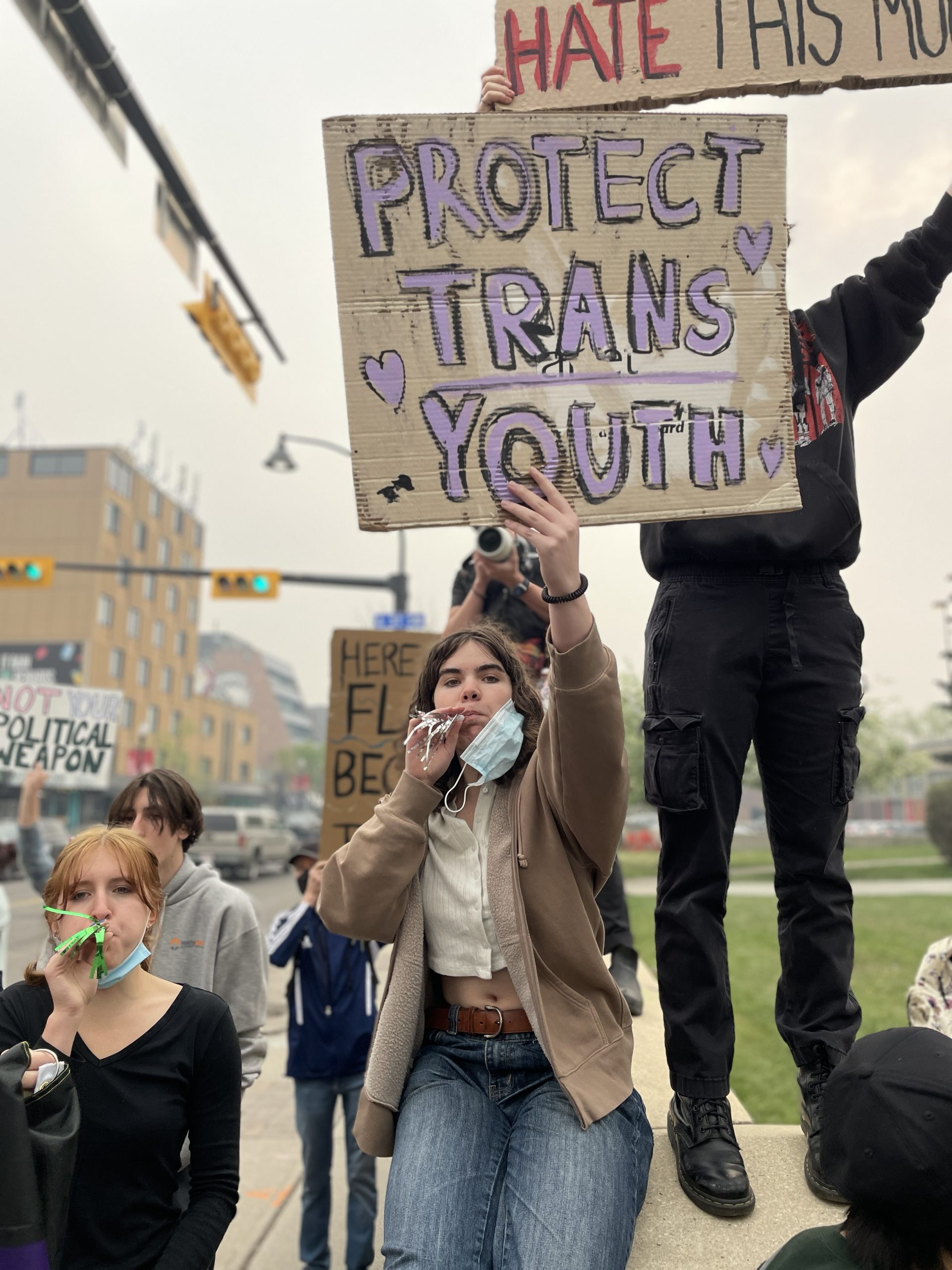 Young people hold signs during a counter-protest outside Calgary’s Western Canada High School on Wednesday, May 27, 2023, the International Day for Homophobia, Biphobia and Transphobia. A right-wing media personality chose the city as the location for an event he called an “International Walkout Protest” campaigning against transgender rights in schools. (Nick Blakeney, CityNews image.)