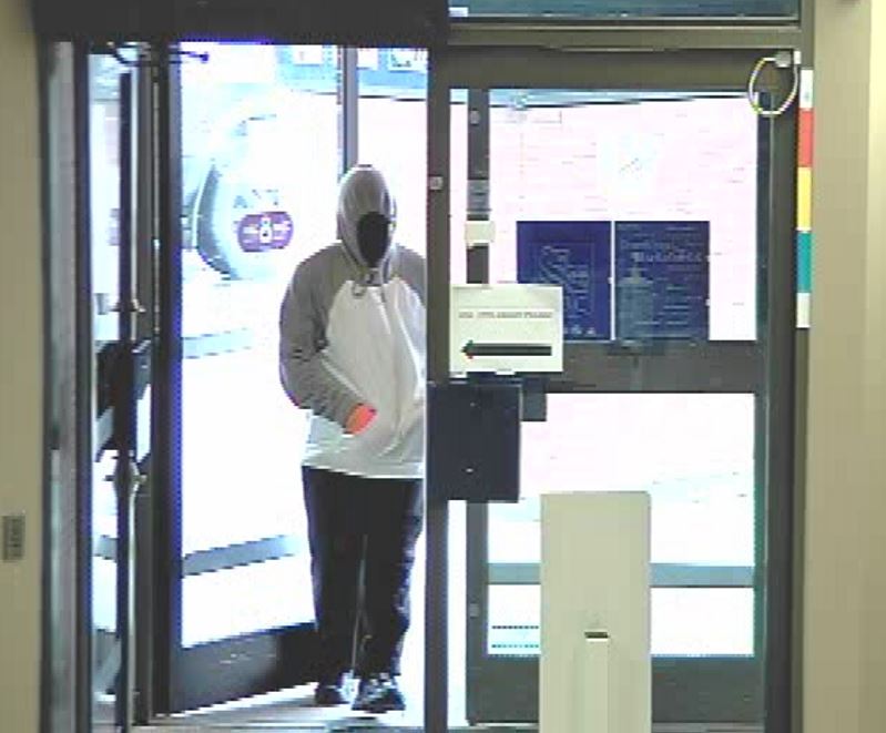 A suspect, on video, walks into a business in High River, Alta
