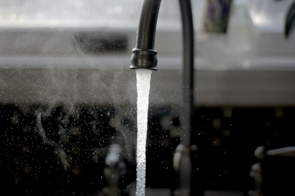 A picture of a faucet running water from a kitchen sink