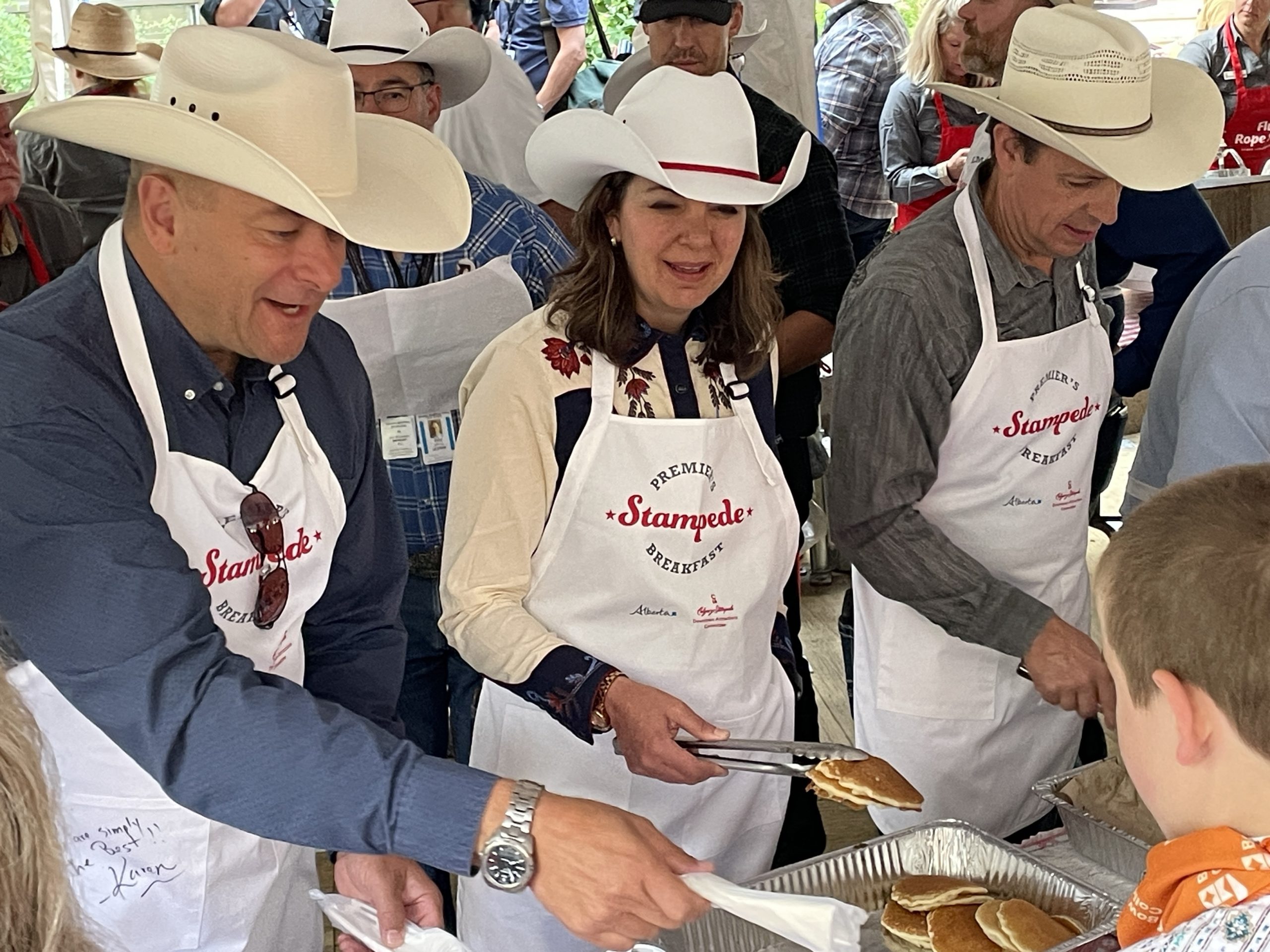 Premier Danielle Smith serves pancakes alongside members of her UCP caucus at the Premier's Stampede Breakfast at Calgary's McDougall Centre on Monday, July 10, 2023