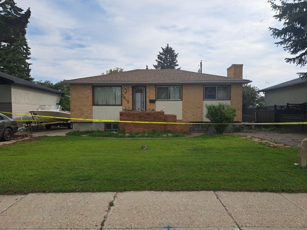 Police tape surrounds a house in the northwest Calgary community of Bowness following the discovery of a woman's body.