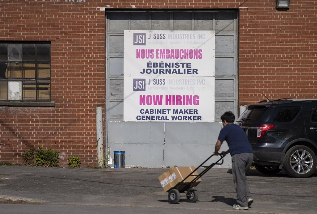 A "Now Hiring" sign is displayed on a business in Montreal