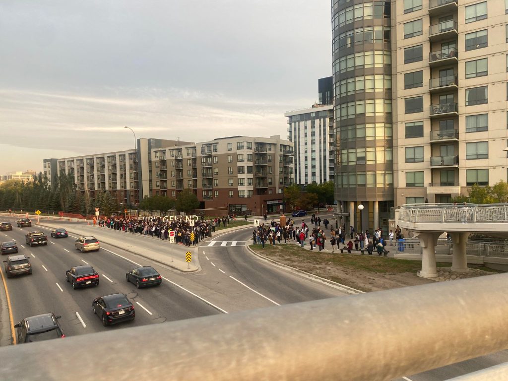 People wait in Bridgeland for a shuttle after mechanical issues shut down C-Train lines heading into downtown on Monday, Sept. 18, 2023.