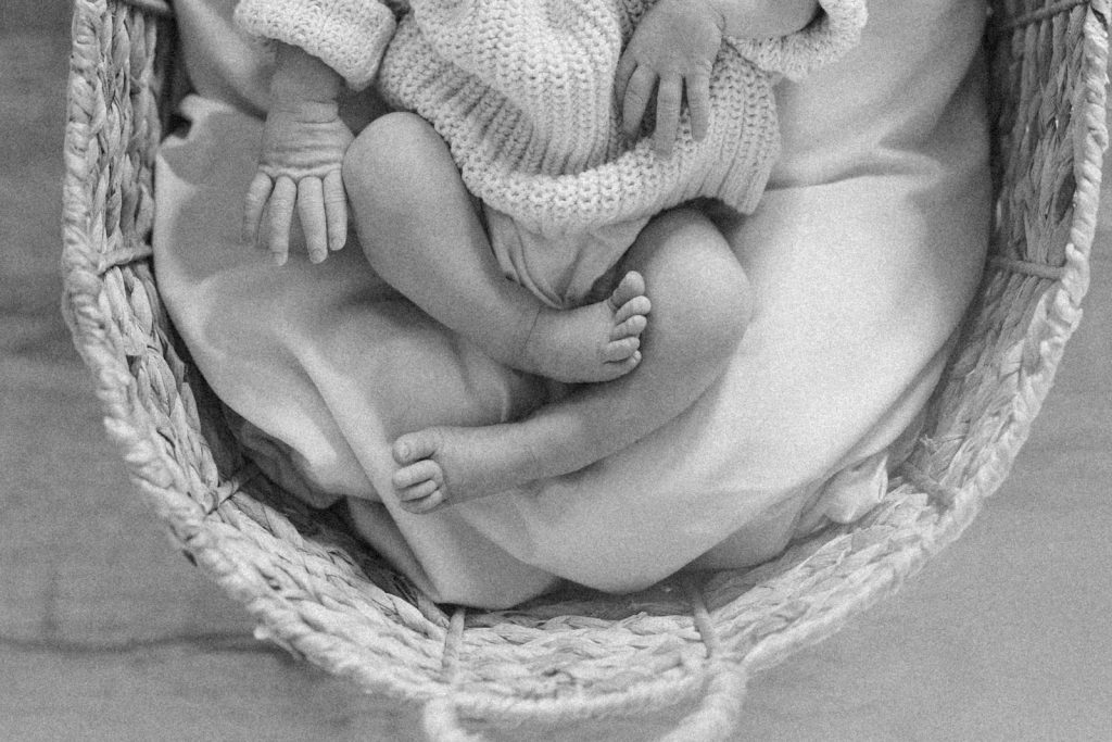 a black and white photo of a baby in a basket