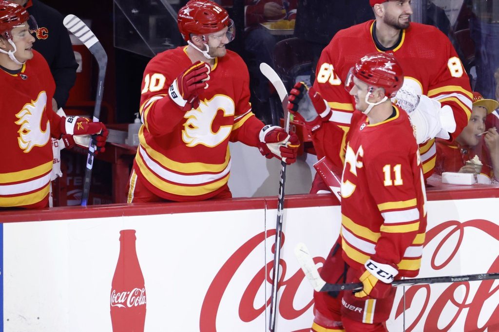 Calgary Flames' Mikael Backlund (11) celebrates his second goal against the Montreal Canadiens with teammate Jonathan Huberdeau (10) during second period NHL hockey action in Calgary, Alta., Saturday, March 16, 2024