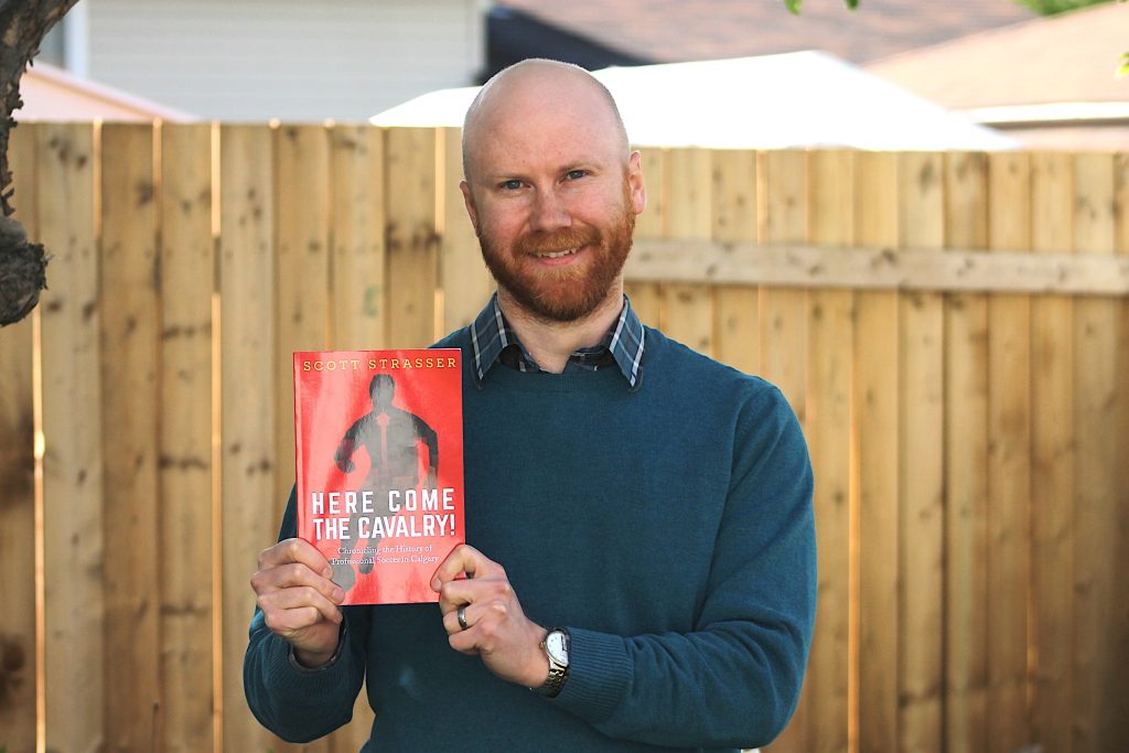 Calgary's Scott Strasser holds his book, 'Here Come the Cavalry!'