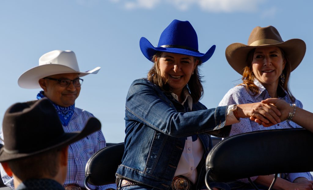 Alberta Premier Danielle Smith, centre, shakes hands before the Stampede Parade kicks off in downtown Calgary on Friday, July 5, 2024