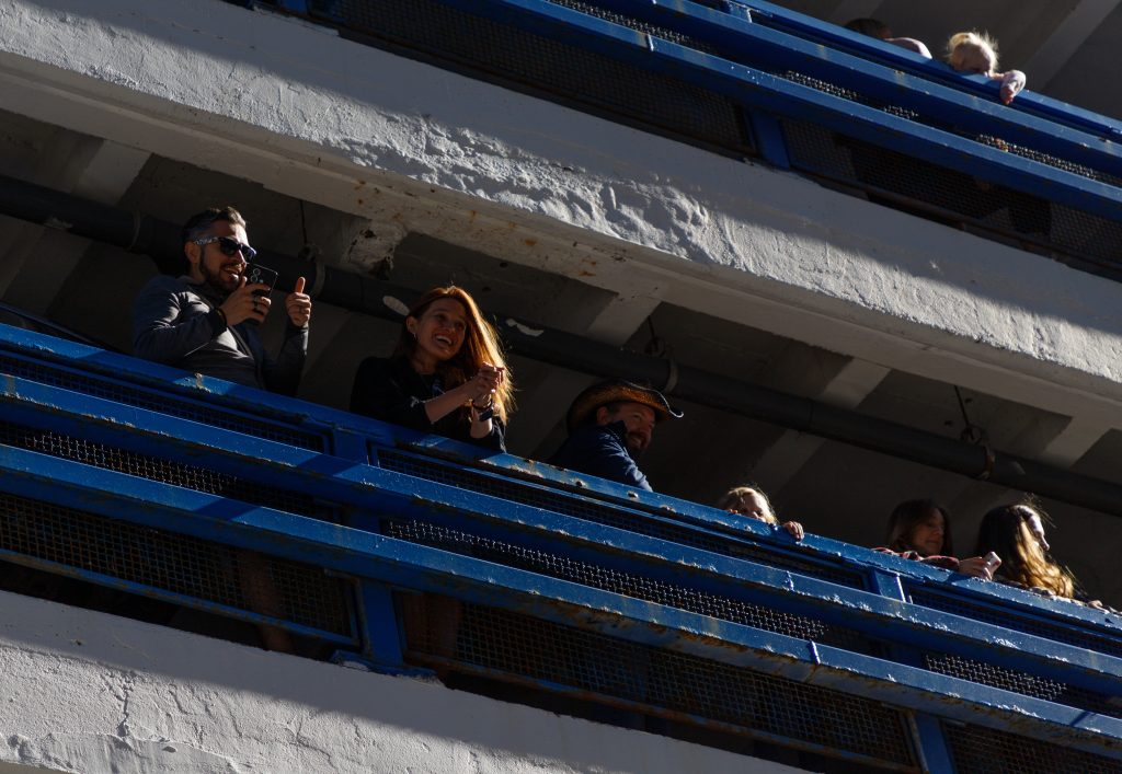 A few spectators smile and take photos as they watch the Calgary Stampede Parade the CORE Parkade in downtown Calgary