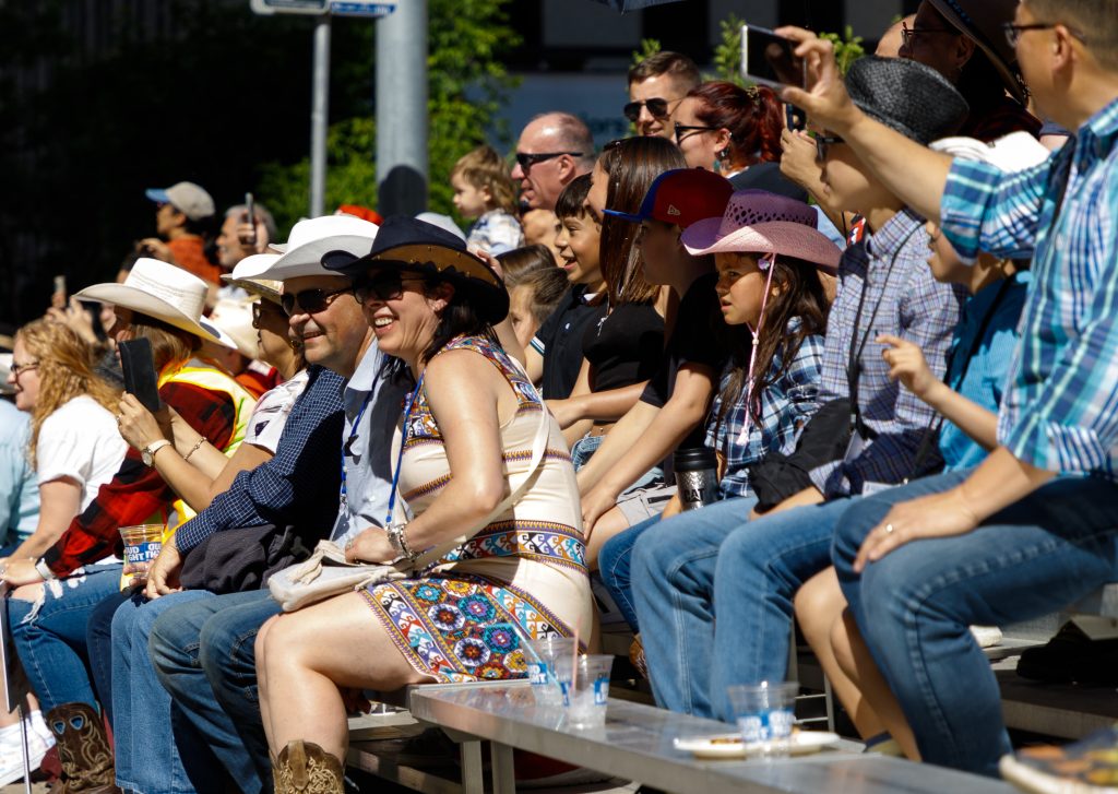 A crowd at the Stampede Parade looks at the various floats and participants in downtown Calgary