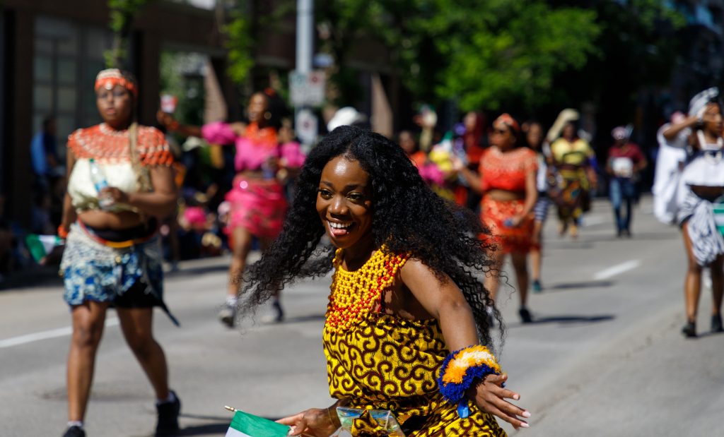 A woman dances as part of the Calgary Nigerian Association in the Stampede Parade in downtown Calgary on Friday, July 5, 2024.